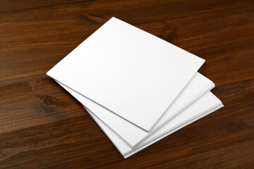 Stack of blank paper sheets on wooden table. Brochure design