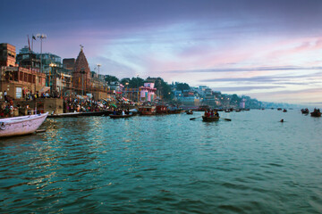 Varanasi, India: People and tourists on wooden boat sightseeing in Ganges river near Munshi ghat...