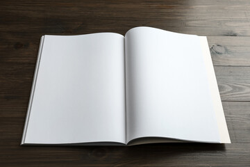 Open blank paper brochure on wooden table. Mockup for design