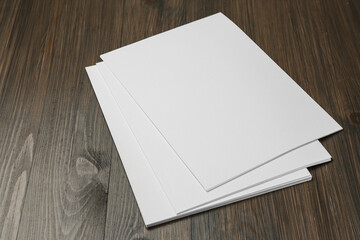 Stack of blank paper sheets on wooden table. Brochure design