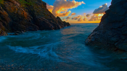Fototapeta na wymiar Entre deux falaises, mer au lever du soleil proche de la plage Bonaparte dans les cotes d'Armor en Bretagne