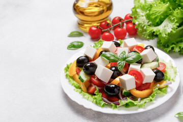 Healthy Greek Vegetables Salad with cheese on white stone table background. Healthy food with fresh vegetables for dinner. Mediterranean cuisine. Close up, copy space