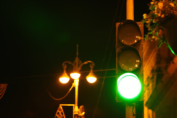 Green traffic light in city at night, space for text