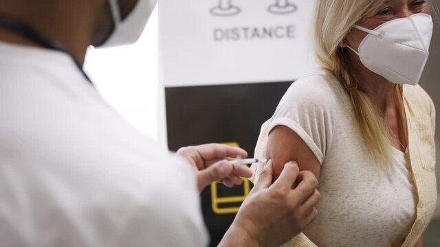 Doctor vaccinating a senior woman. Coronavirus concept.