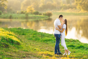 couple of travelers standing on the shore of the lake and admiring each other kissing. Walking in the fresh air.