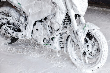 motorcycle in white foam at a car wash