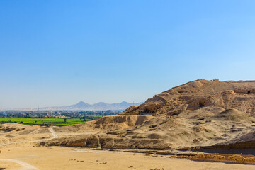 Archeological site near the temple of Hatshepsut in Luxor, Egypt. Green landscape on a background