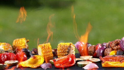 Assorted delicious grilled vegetables placed on grill with fire.