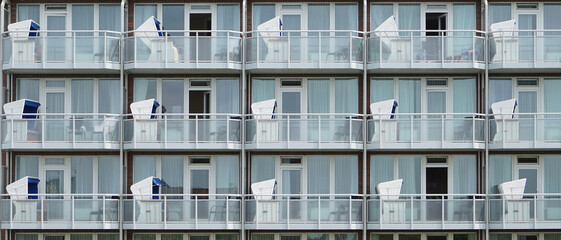 Fototapeta na wymiar Ferienwohnungen Apartment Haus mit Balkonen und Liegen am Meer 