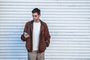 portrait of young man on the street with mobile phone