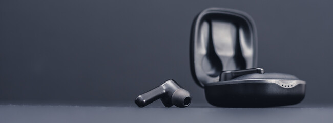 Blank wireless bluetooth earphones on black background - obrazy, fototapety, plakaty