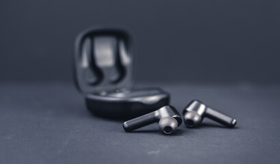 Blank wireless bluetooth earphones on black background