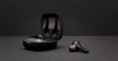 Blank wireless bluetooth earphones on black background