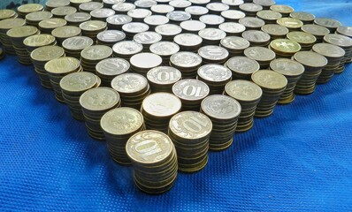 On the table there are stacks of copper coins. Coins with a denomination of 10 Russian rubles. Many coins. People wink and counting money. Coinshot machines. Sorting coins in a bank. 