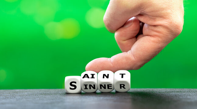 Hand turns dice and changes the word "sinner" to "saint".