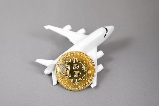 Blockchain airline ticket concept. Bit coin digital currency cryptocurrency. Gold coin, plane on grey background. electronic virtual money. Color year 2021 illuminating and ultimate gray pantone.