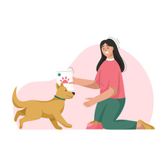 Woman is feeding dog. Owner takes care of puppy