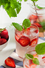 A refreshing summer drink with strawberries, lime and mint in a glass. Ice-cold summer lemonade.