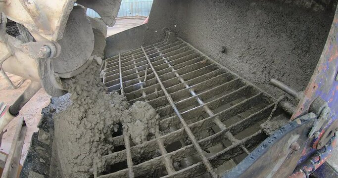 concrete falls from the concrete mixer onto the grate of the feeding machine