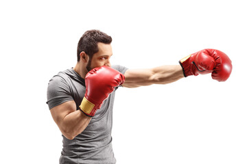 Strong young man punching with boxing gloves