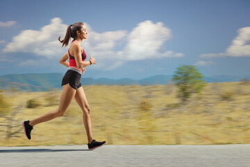 Female athlete jogging outdoors on an open road