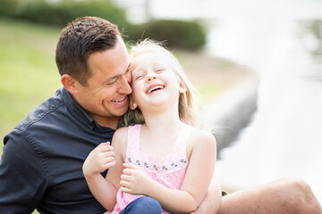 Naklejka premium Young Caucasian Father and Daughter Having Fun At The Park