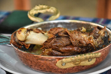 goat meat cooked in tandoor served on copper plate at garden restaurant 