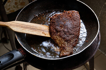 The Cook is Cooking Fried Fermented Fish, Pickled Fish in the Kitchen for Lunch.