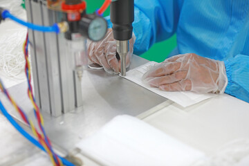 Workers are busy on the production line in a Medical mask factory.