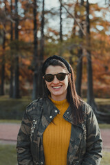 Portrait of a young smiling woman outdoors in autumn.