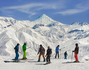 The view of skiers and Mount Damavand from Darbandsar ski resort in Tehran, Iran.