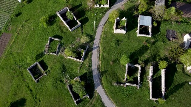 Ruined and damaged houses in village as war aftermath. Aerial drone view of homes destroyed and burned in war by artillery. Abandoned buildings. Houses ruins. 