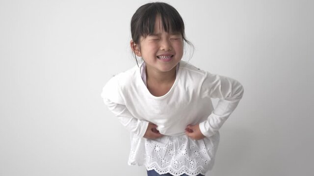 腹痛でお腹を押さえる女の子