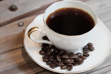 木目の机に置いたコーヒー豆とカップ