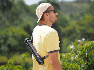 The man in nature, wearing a carbon tripod for travel on his back.