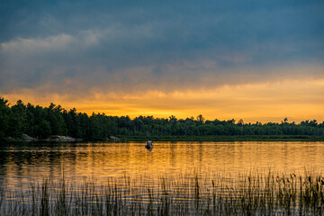 Sunset above forest lake