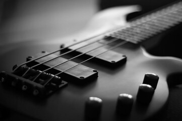 Closeup shot of a smooth body, pickups, bridge, knobs and strings of a bass guitar musical instrument with backlight