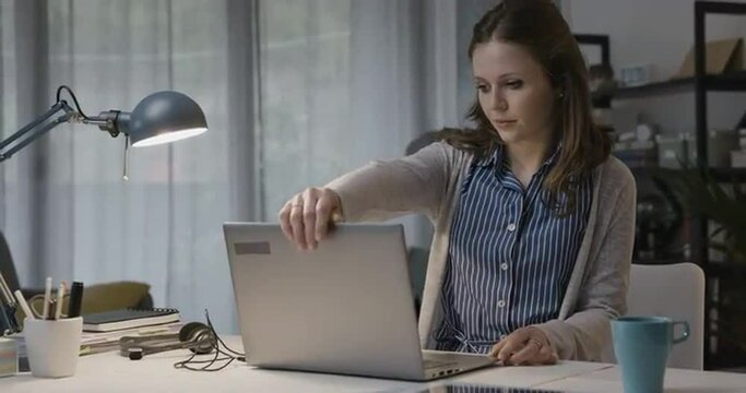 Woman sits at desk and starts working