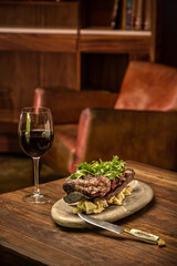 beef steak with red wine on a table and an armchair to celebrate father's day