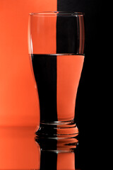 refraction of light by a glass on a red and black squared background. Abstract glass art.
