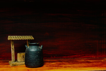 House decoration, water well and ceramic vessel. Little and rustic decoration on wooden furniture.