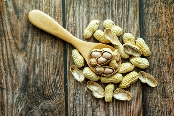 Peanuts on wooden spoon.