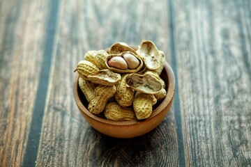 Peanuts on wooden bowl.