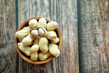 Peanuts on wooden bowl.