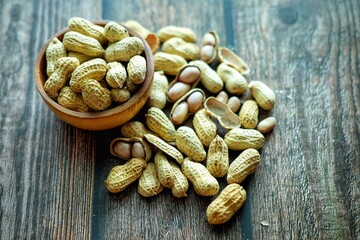 Peanuts on wooden bowl.