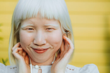 Cute albino girl listening to her favorite music through earphones - obrazy, fototapety, plakaty