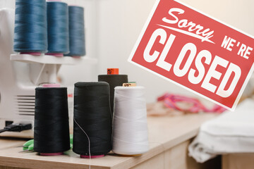Sorry we are closed sign on the background of clothing atelier