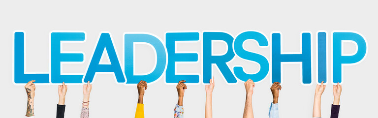 Hands holding up blue letters forming the word leadership