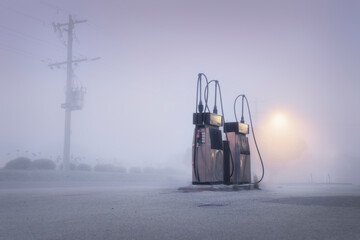 Old fashioned gas pumps on a foggy street at dawn 