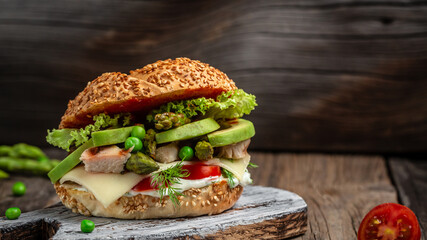 Delicious burger with chicken fillet, asparagus, avocado, tomatoes, peas, cheese and tartar sauce....